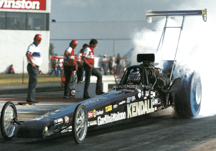 A man is competing in a drag race, driving his powerful drag car.