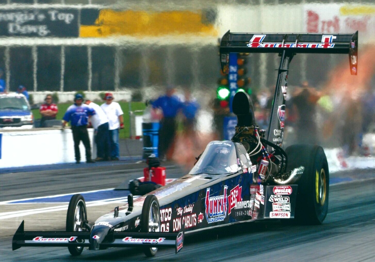 The most advanced design Top Fuel dragster ever designed, built by Murf McKinney and Garlits in 1992, SR 34 was campaigned from 1993-1994 with Bruce Larsen and Richard Langson driving. SR 34 was stored till 2002, brought out of retirement, refurbished with a new engine and drive train and campaigned in 2002 and 2003 with Big Daddy driving. Don drove a blistering quarter mile at 323.04 MPH at the NHRA 2003 Gatornationals, a 318.54 at the 2002 US Nationals and a 319 MPH at 4.73 seconds at the 2003 NHRA Southern Nationals in Atlanta. SR 34 gained more MPH from the 1/8th mile to finish line on the 323.04 run than any other top fuel dragster had up to that point.  This proved beyond a show of a doubt, SR 34 aerodynamics superiority.  Of course, NHRA was in the process of slowing the top fuel cars down, so they did not want any of the Mono-Wing cars to be campaigned by the other top fuel teams. SR 34 has enclosed cockpit, extra narrow rear and the aerodynamic “T” tail section, (Mono-Wing). These three things make the car most advanced T/F Dragster ever built. 